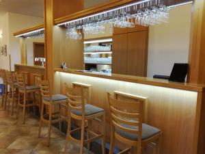 a bar with a row of stools in a restaurant at Hotel Berounka in Liblín