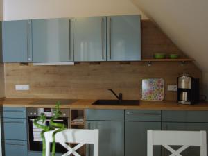 een keuken met blauwe kasten en een wastafel bij Comfortable Holiday Home in Wismar near Baltic Sea in Wismar