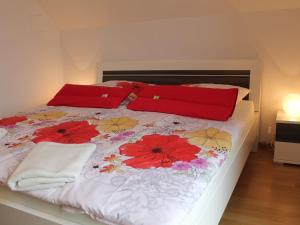 ヴィスマールにあるSplendid Apartment in Wismar with Balconyの赤い枕と花が飾られたベッド