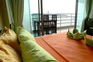 芭達雅中心的住宿－塔萊美景6套房公寓，一间卧室设有一张床,享有阳台的景色