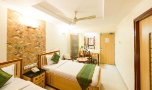 a hotel room with two beds and a bathroom at Treebo Trend Paradise in Ahmedabad