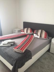 een bed met gestreepte dekens en kussens erop bij Augsburger Apartment in Augsburg