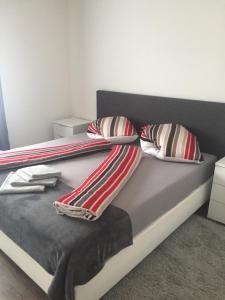 ein Bett mit gestreiften Decken und Kissen darauf in der Unterkunft Augsburger Apartment in Augsburg