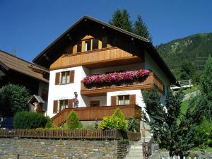 une maison avec des boîtes de fleurs sur son côté dans l'établissement Haus Enzian, à Sankt Anton am Arlberg