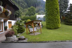 a garden with a bench and a gazebo at Haus Wasserfall in Sankt Gallenkirch
