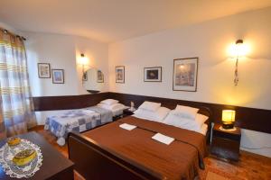 um quarto de hotel com duas camas e uma mesa em Apartment Petrlin em Malinska