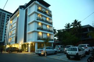 un edificio alto con auto parcheggiate in un parcheggio di Niko Hotels a Cochin
