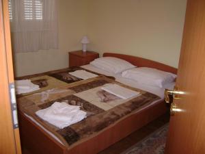 - une chambre avec un lit et des serviettes dans l'établissement Dalmacia apartments, à Srima