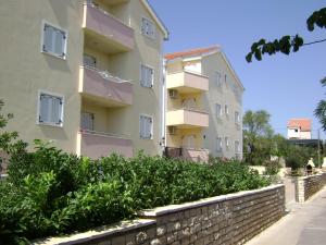 un immeuble d'appartements avec un mur de retenue à côté d'une clôture dans l'établissement Dalmacia apartments, à Srima