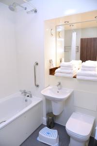 a bathroom with a sink and a tub and a toilet at Woodcocks, Lincoln by Marston's Inns in Lincoln