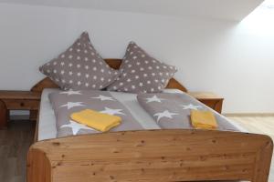 a bed with gray and gray pillows on it at Gasthof Rössle Ochsenwang in Bissingen an der Teck