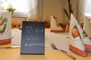 a table with a sign that says i wish will kommen at Gasthof Rössle Ochsenwang in Bissingen an der Teck