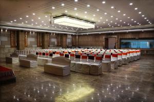 uma grande sala com fileiras de mesas e cadeiras em SilverCloud Hotel and Banquets em Ahmedabad