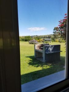 a window view of a bench in a field at Cabañas Arcángeles de Tandil in Tandil