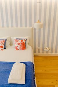 a bedroom with a bed with blue and white stripes at Loving Chiado in Lisbon
