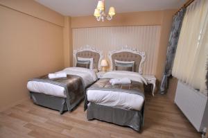 a hotel room with two beds and a chandelier at Divani Ali Hotel in Istanbul