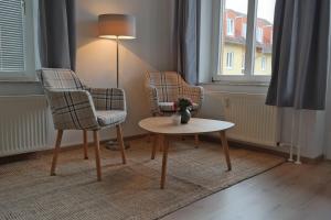 uma sala de estar com duas cadeiras, uma mesa e um candeeiro em Ferienwohnung Wartburgblick em Eisenach