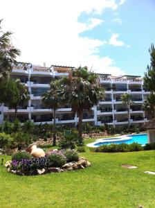 a large apartment building with a garden and a swimming pool at Mi Capricho in Sitio de Calahonda