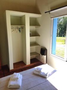 a room with two towels on a bed with a window at Cabañas Arcángeles de Tandil in Tandil