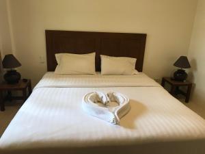 uma toalha em forma de coração está sentada numa cama em Palm Garden em Ko Chang