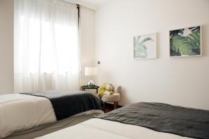 リスボンにあるParque das Nações - Fil Pool Apartmentのベッドルーム1室(ベッド2台、窓付)