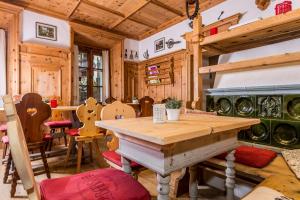 uma sala de jantar com uma mesa de madeira e cadeiras em Gasthaus Babsi em Soprabolzano