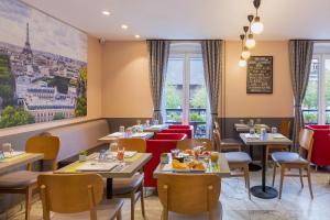 restauracja ze stołami, krzesłami i oknami w obiekcie Contact Hôtel Alizé Montmartre w Paryżu