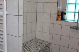 a shower with a bench in a tiled bathroom at Gasthof Rössle Ochsenwang in Bissingen an der Teck