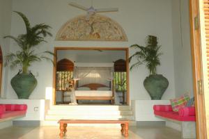 a bedroom with a bed and a mirror and a table at Khomba Beach House in Alankuda