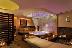 a room with a tub and a bedroom with a bed at Mövenpick Resort & Marine Spa Sousse in Sousse