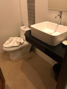 a bathroom with a white sink and a toilet at Amarina Green in Lamai