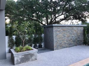a brick wall with a tree in a courtyard at Amarina Green in Lamai