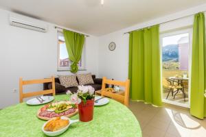 a living room with a table with food on it at Apartments Mirica in Baška