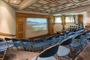 an empty room with chairs and a screen at Hotel le Petit Dru in Morzine +37 photos