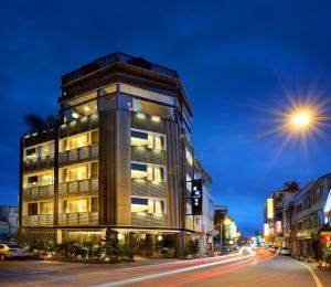 礁溪鄉的住宿－東旅湯宿溫泉飯店 - 信義館，夜幕降临的城市街道上一座高楼