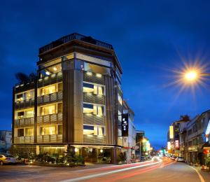 a tall building on a city street at night at Yunoyado Onsen Hot Spring Hotel -Xinyi Branch in Jiaoxi