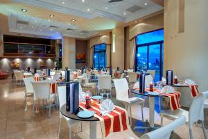 a restaurant with tables and chairs in a room at Paradise Bay Resort in Mellieħa