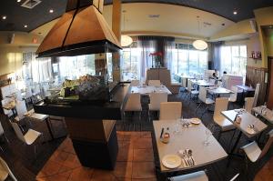 a dining room with tables and chairs in a restaurant at Hôtel Énergie Shawinigan in Shawinigan