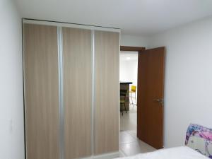 a bedroom with a wooden closet with a door at Le Bon Vivant 108 in Arraial do Cabo +59 photos