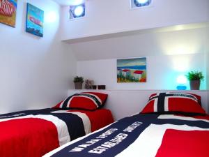 twee bedden in een kamer met rood en wit bij Boathotel Rotterdam Seven in Rotterdam