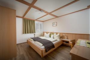 ein Schlafzimmer mit einem Bett und einem Schreibtisch in einem Zimmer in der Unterkunft Ferienwohnungen Vordergriess in Hochfilzen