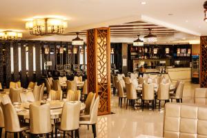 a restaurant with tables and chairs and a bar at Jing Pin Hotel in Koror