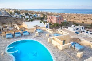 an image of a pool with umbrellas and the ocean at Anemoessa Villa in Oia