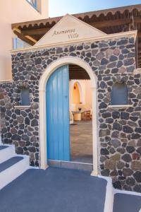 a doorway leading to a building with a blue door at Anemoessa Villa in Oia