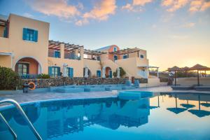a villa with a swimming pool in front of a building at Anemoessa Villa in Oia