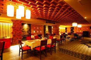 um restaurante com mesas e cadeiras num quarto em Crystal Palace Hotel em Manama