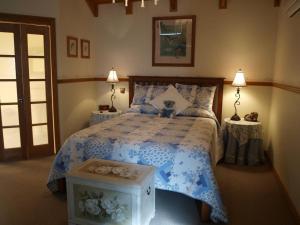 a bedroom with a blue and white bed with two tables at Cottages on Edward in Deniliquin