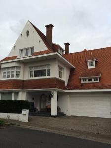 a large white house with a red roof at Bed & Breakfast Esprit de Mer in De Panne