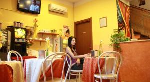 una mujer sentada en una mesa en un restaurante en Hotel San Giovanni, en Milán