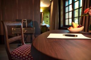 RegensbergにあるHotel Krone Regensbergの果物のボウルとペンが置かれたテーブル